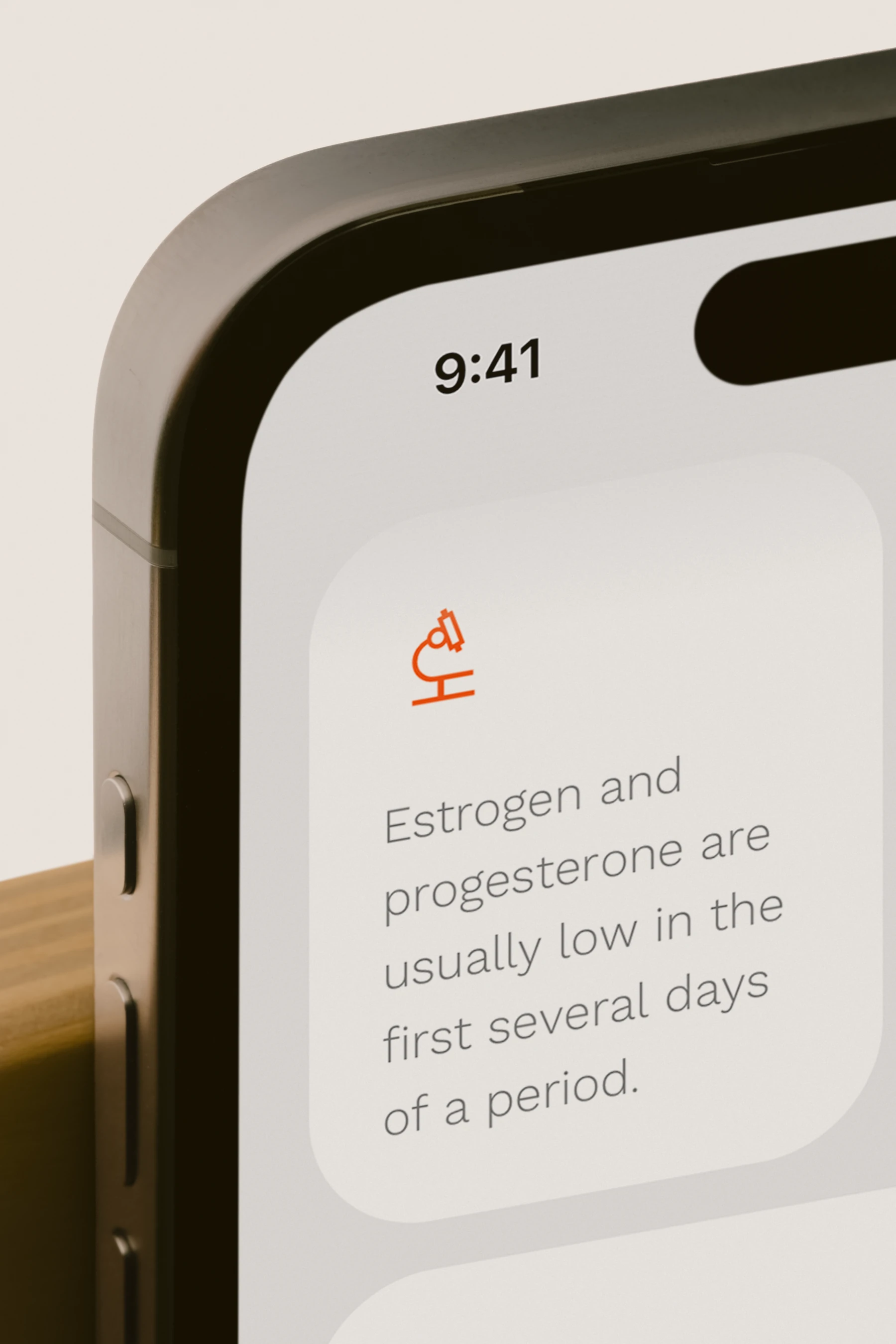 Close-up of a phone showing a field. Learn card about estrogen and progesterone